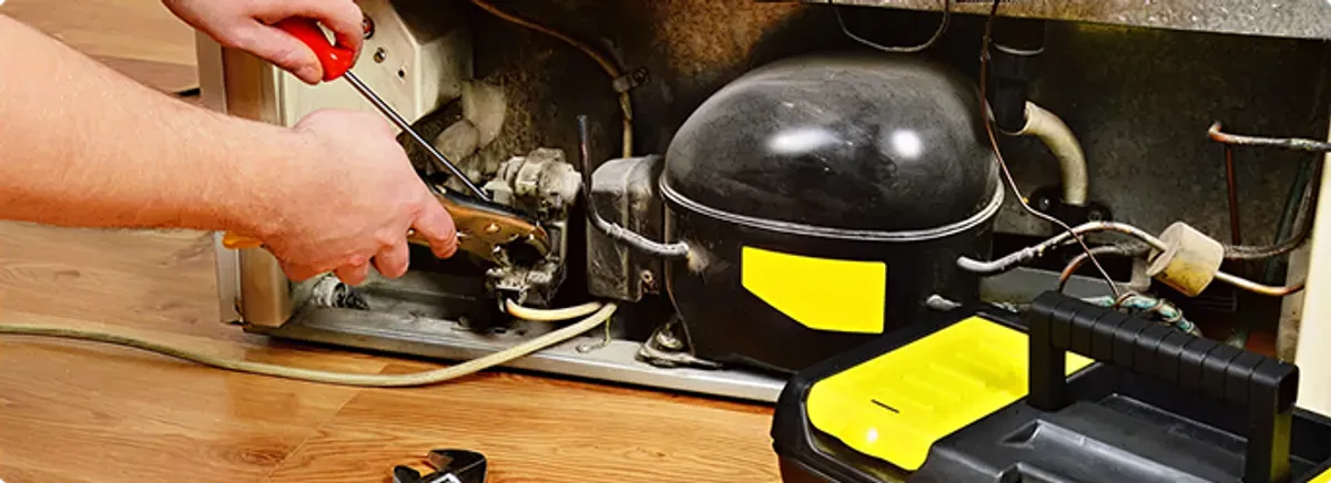 Refrigerator repair technician fixing the compressor and wiring in Mc Kean, PA