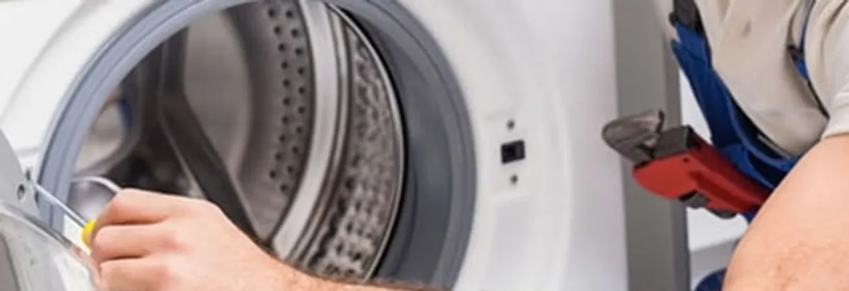 Appliance technician repairing a clothes dryer drum and internal parts in Erie, PA